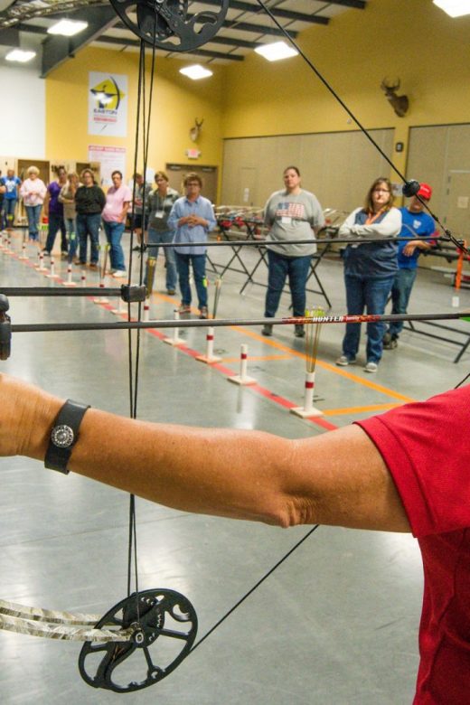 Archery instructor demonstrating compound bow