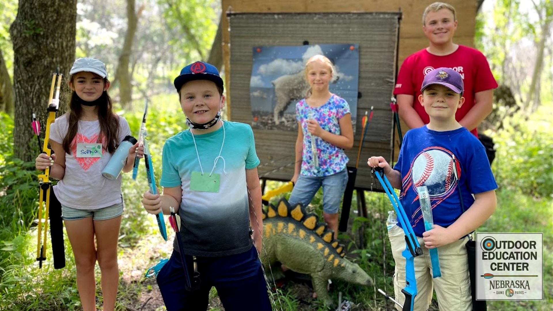 young archers posing w dino target
