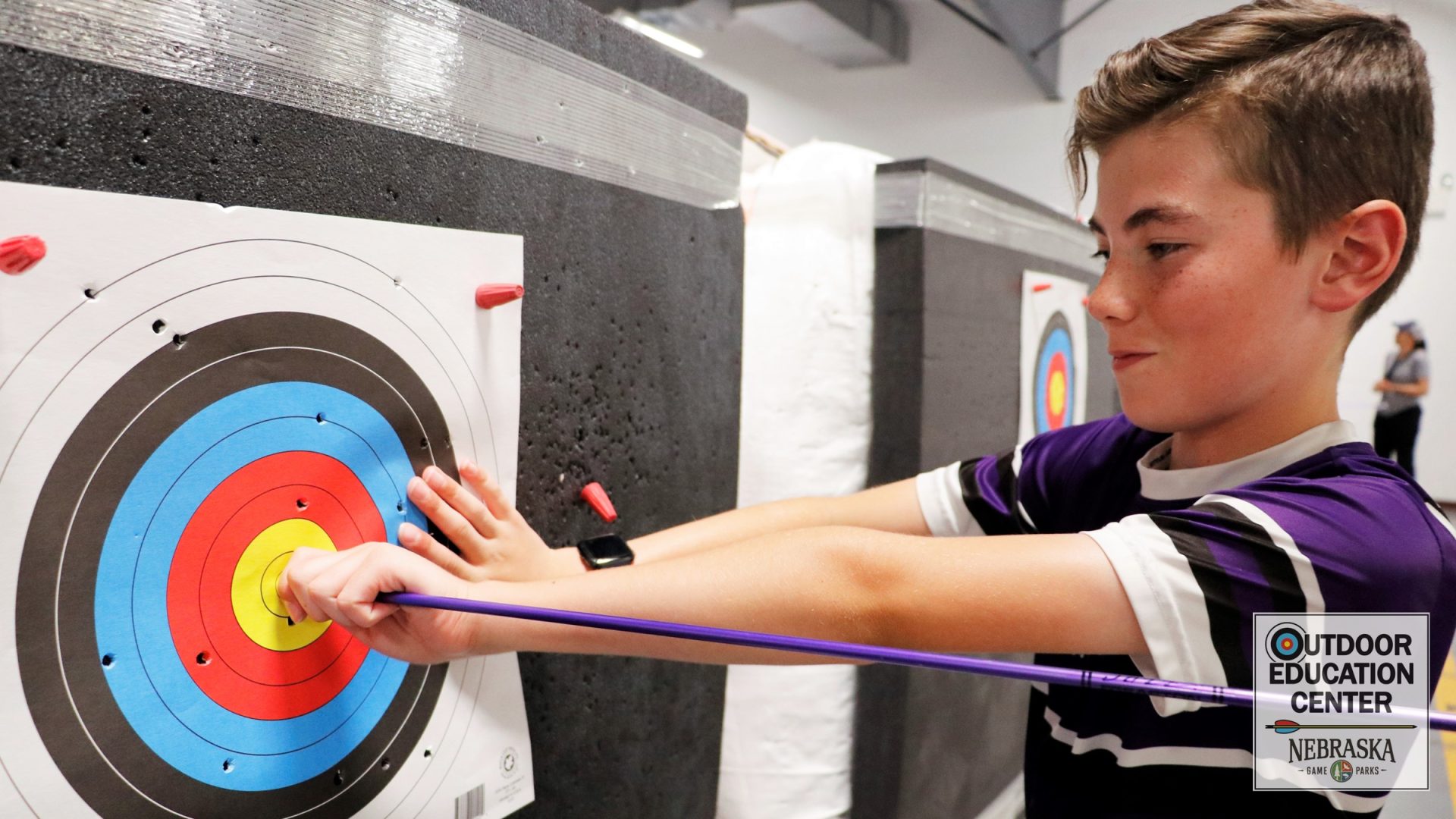 Youth archer pulling arrow from target