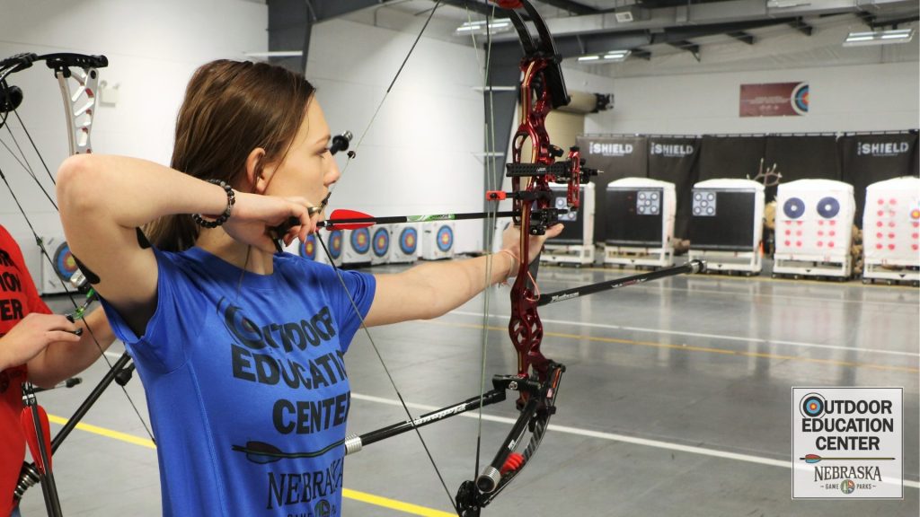 Archer aiming bow at indoor target