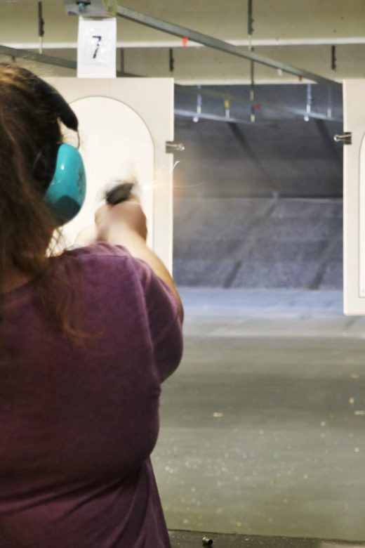 Markswoman shooting at target on indoor range