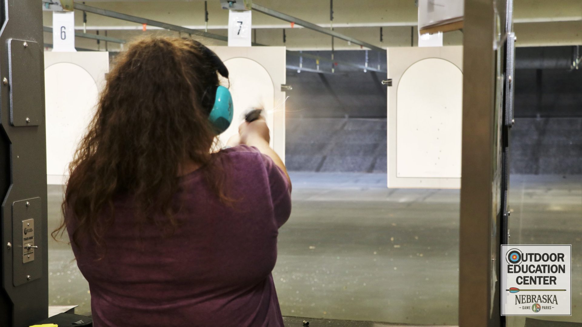 Markswoman shooting at target on indoor range