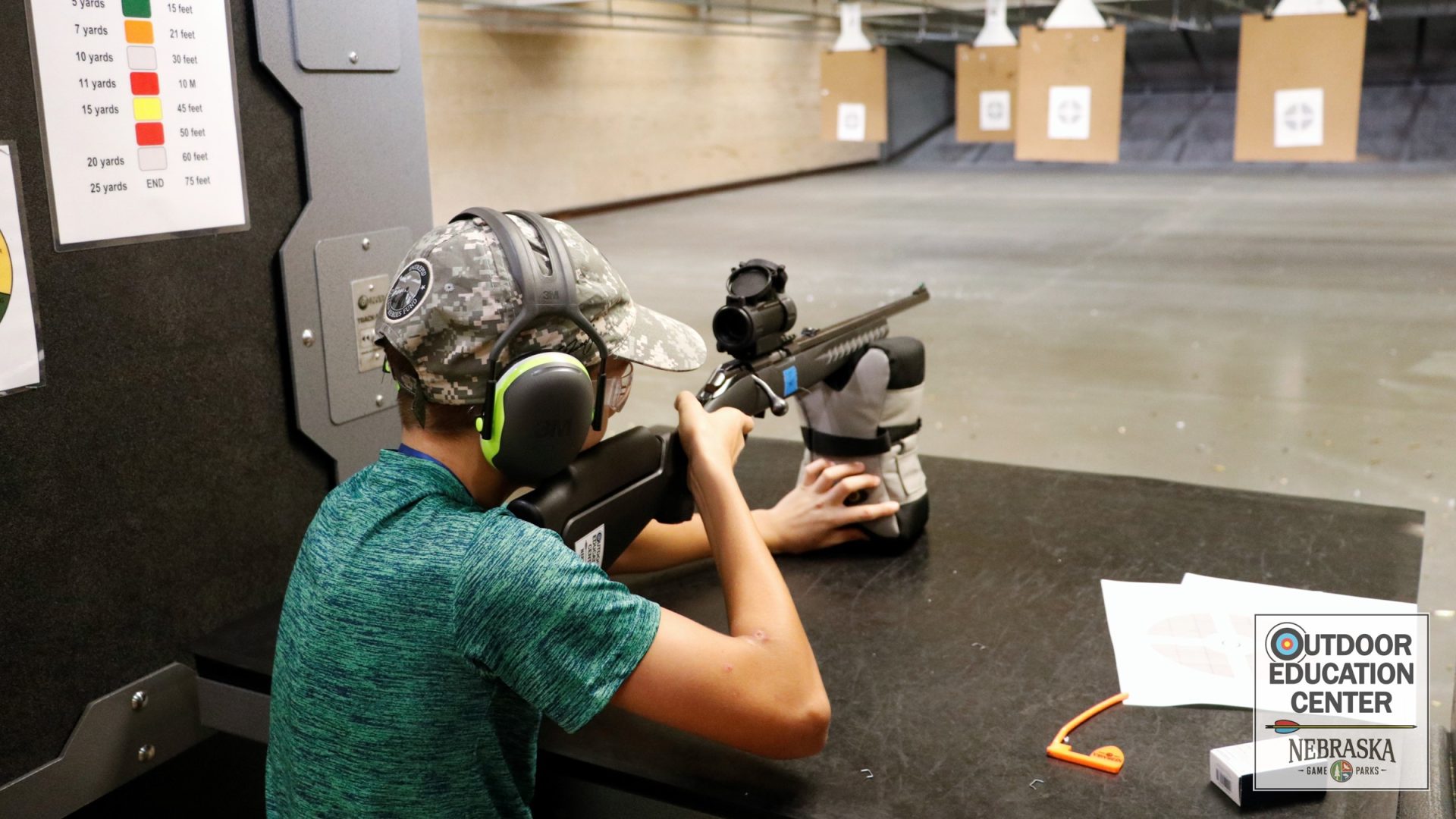 Young student takes aim with bolt action rifle in firearm range