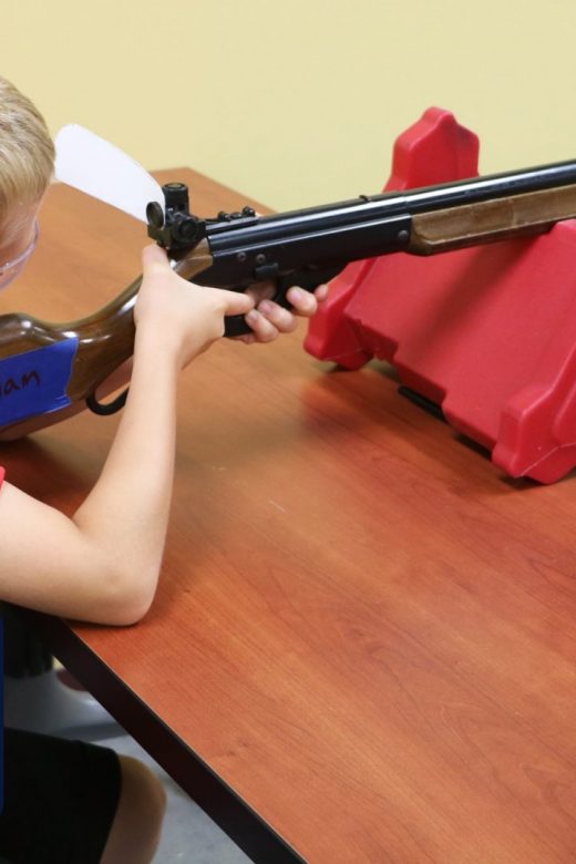 Youth using bench position to take accurate shot with BB gun