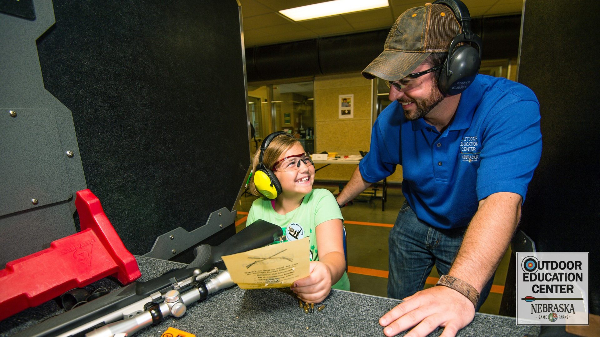 Student and instructor look at rifle target in firearm range
