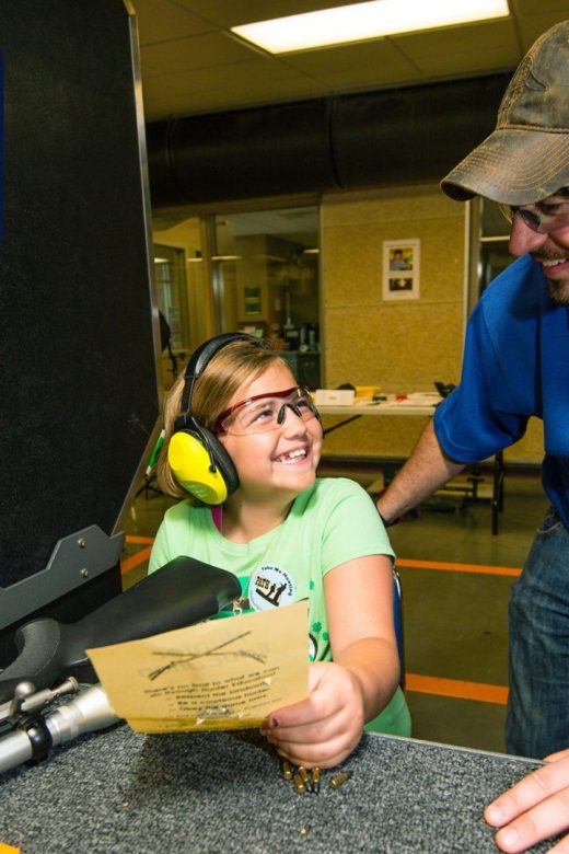 Student and instructor look at rifle target in firearm range