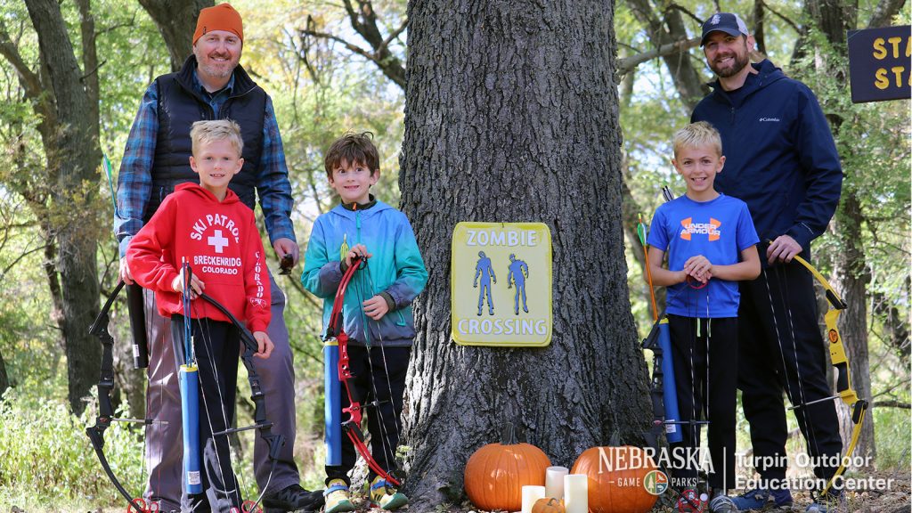 Family in fall setting posing with bows