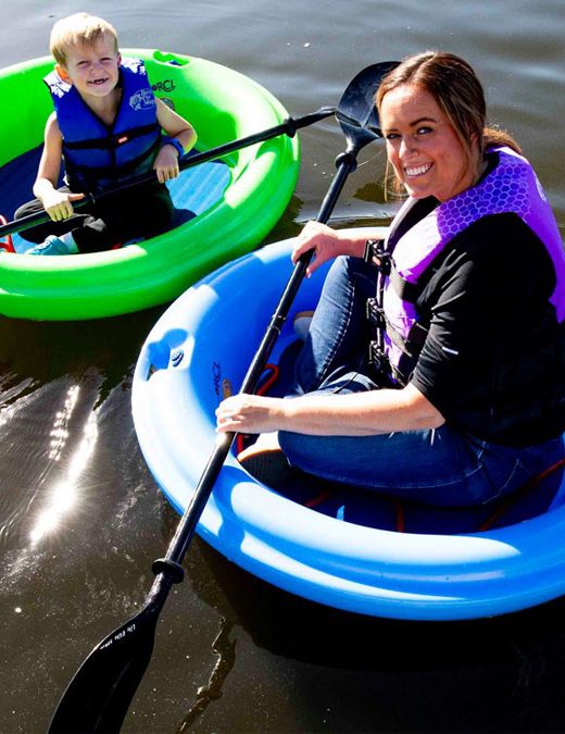 A mother and son float in round rafts at Schramm Park.
