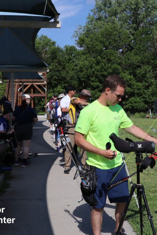 People shoot archery at an outdoor range.