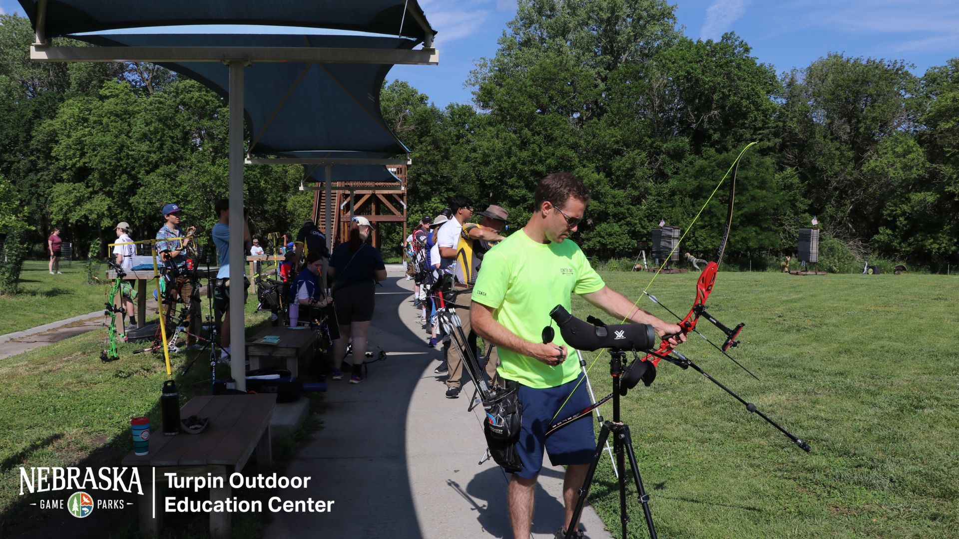 People shoot archery at an outdoor range.