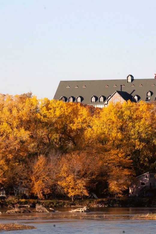 Autumn view from across the river of Peter Kiewit Lodge at Mahoney State Park