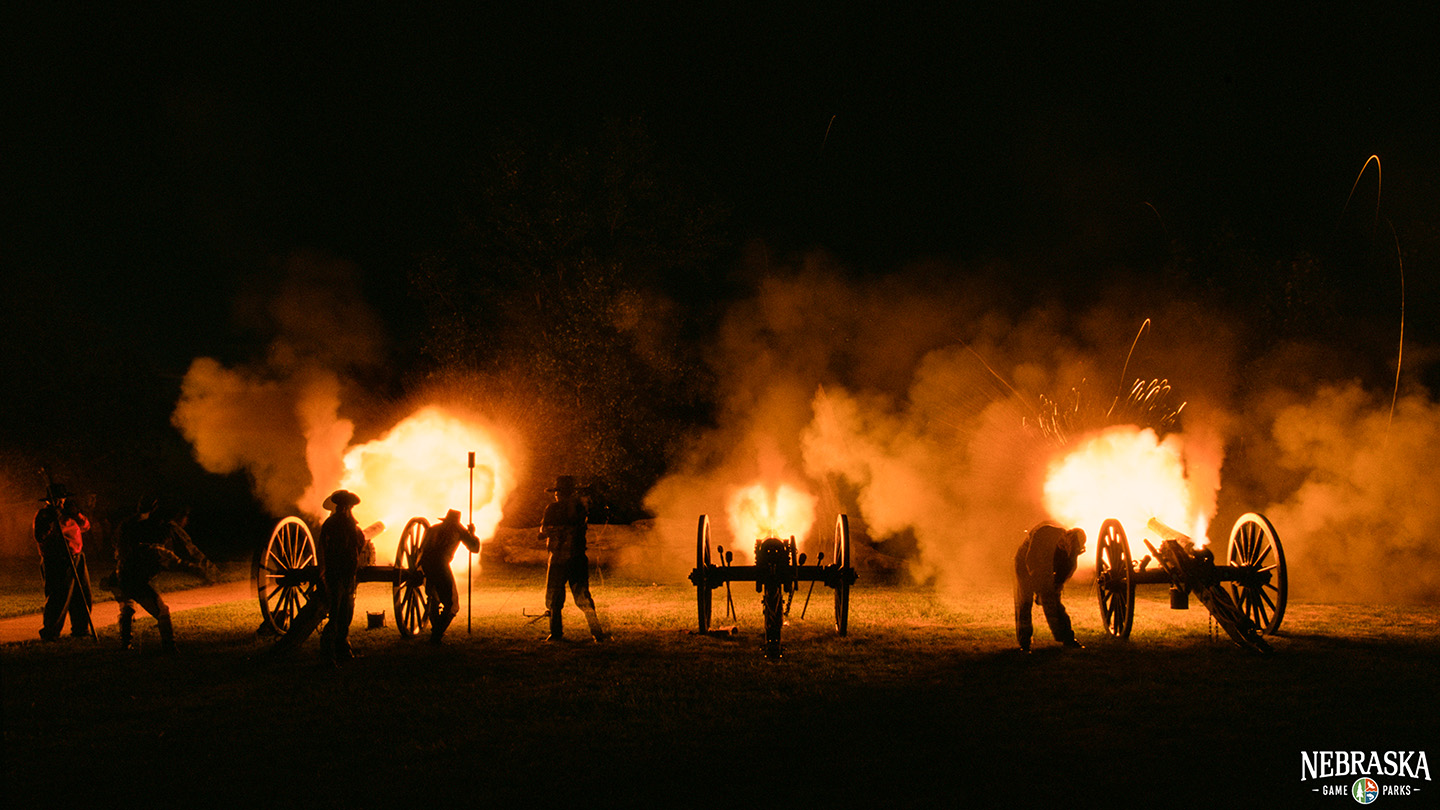 A night shot of historical reenactors lighting off canons at Fort Kearny State Historical Park.