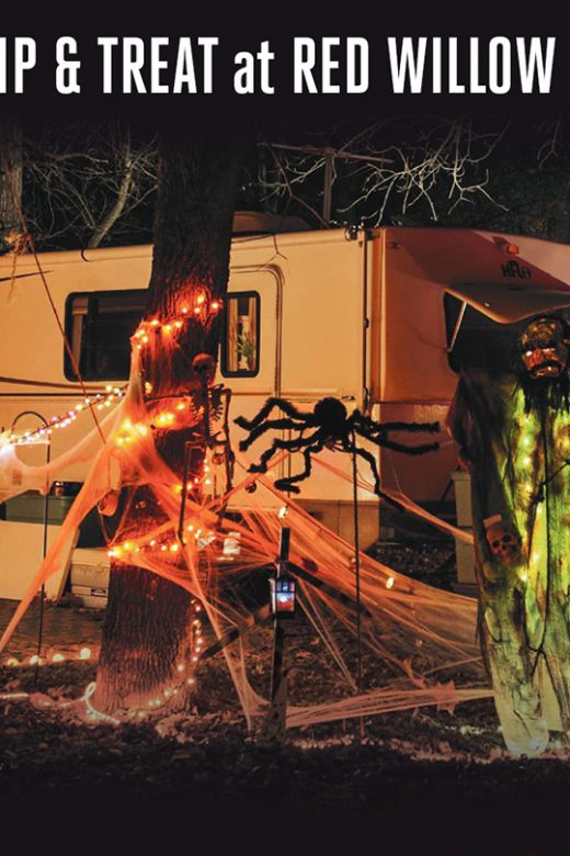 A campground is decorated with spooky Halloween decor at night.