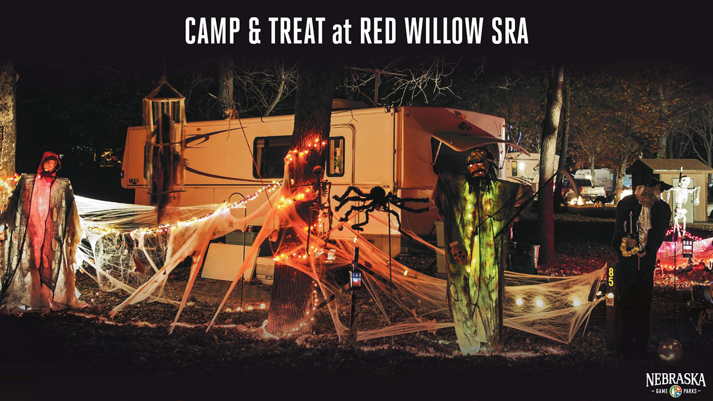 A campground is decorated with spooky Halloween decor at night.