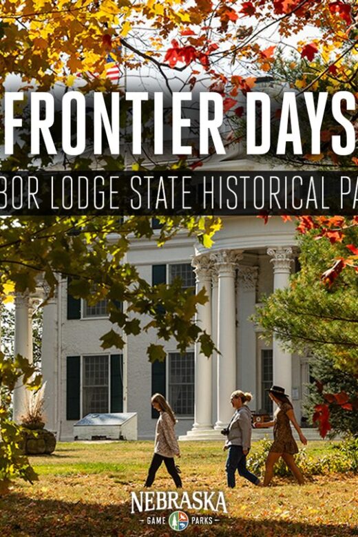 Fall scene of Arbor Day mansion with people walking on a trail.
