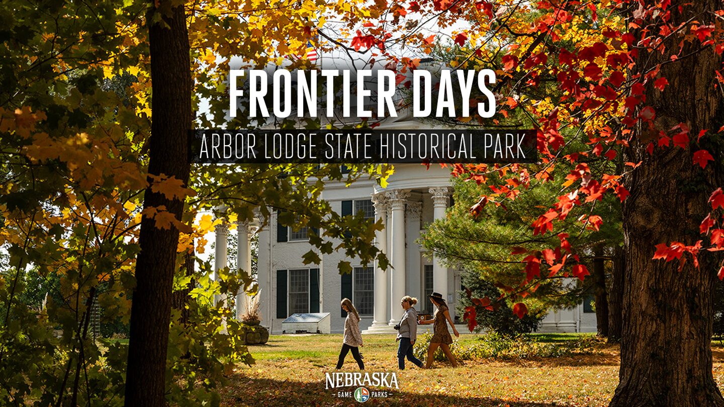 Fall scene of Arbor Day mansion with people walking on a trail.