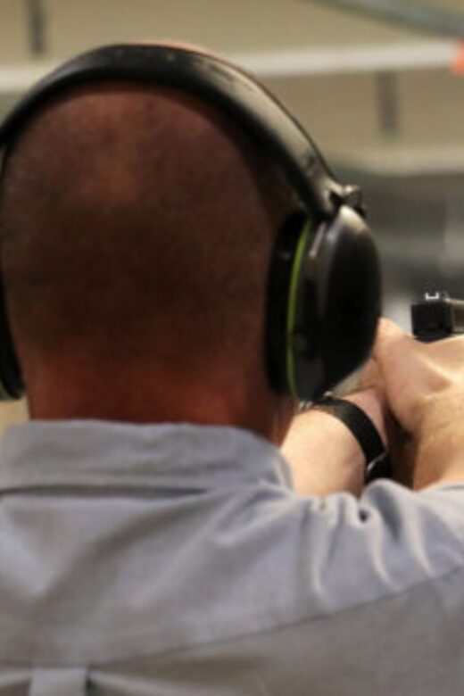 A man practices shooting firearms at an indoor range.