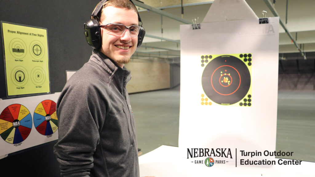 A man practices target shooting at an indoor range.