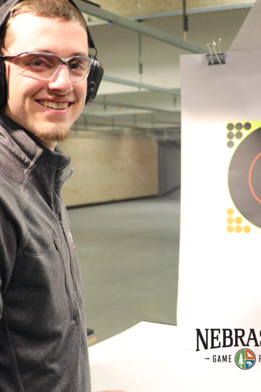 A man practices target shooting at an indoor range.
