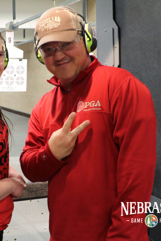 Two people at an indoor shooting range.