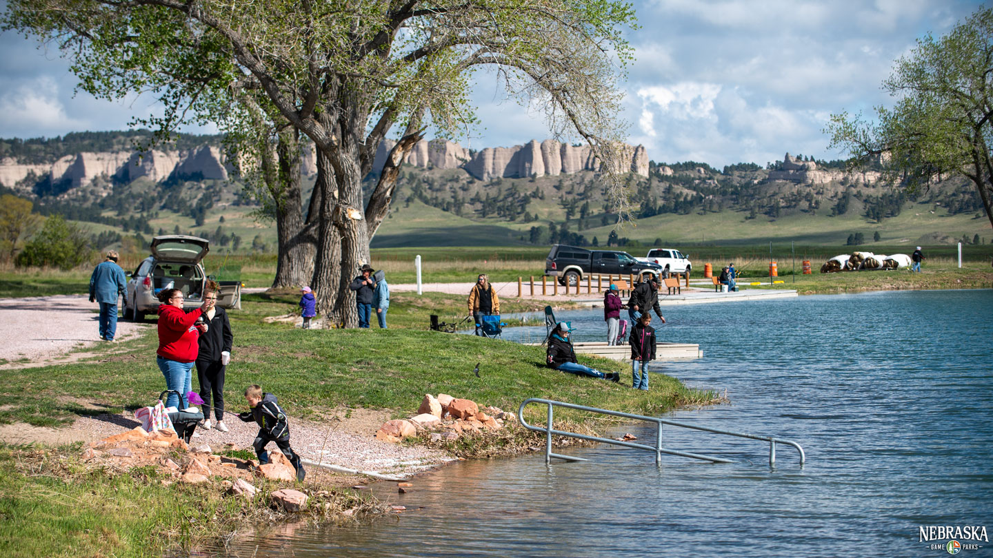 A crowd of people fishes during a fishing derby at Fort Robinson State Park during spring.