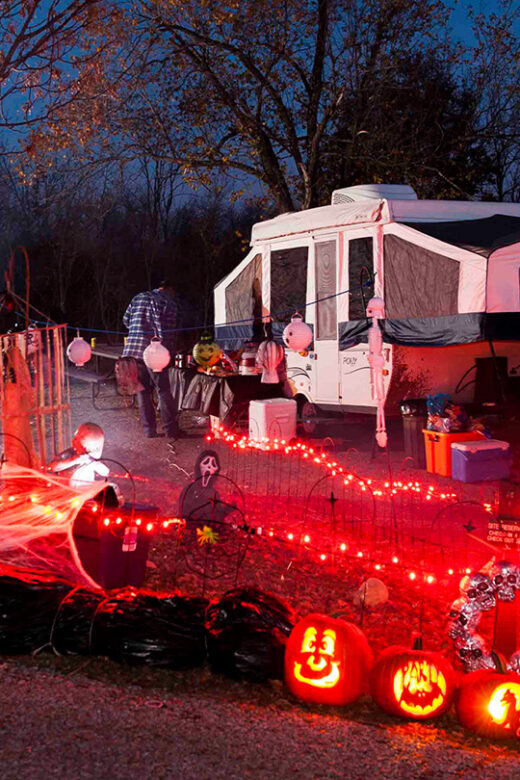 A campground lit up at night with spooky Halloween decor.