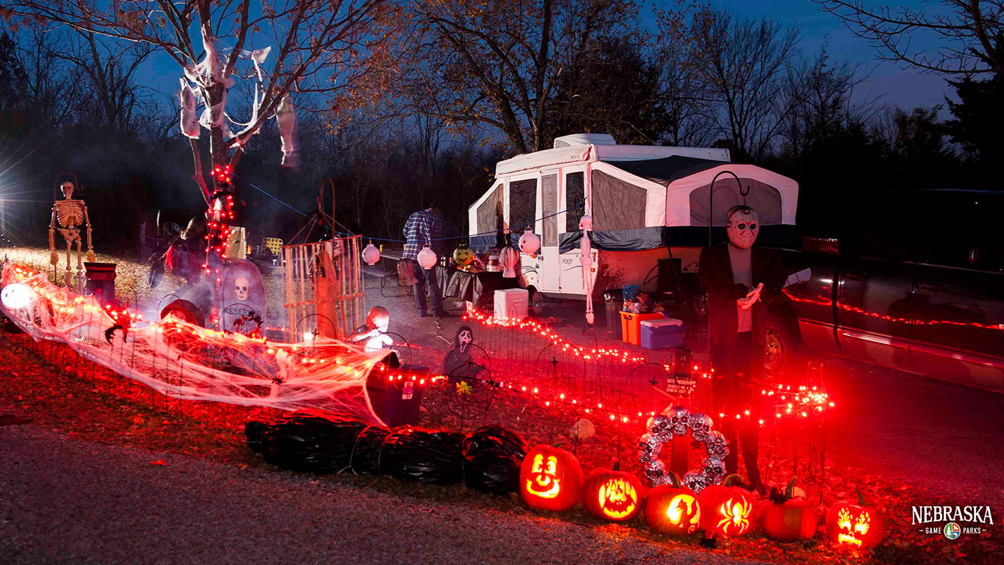 A campground lit up at night with spooky Halloween decor.