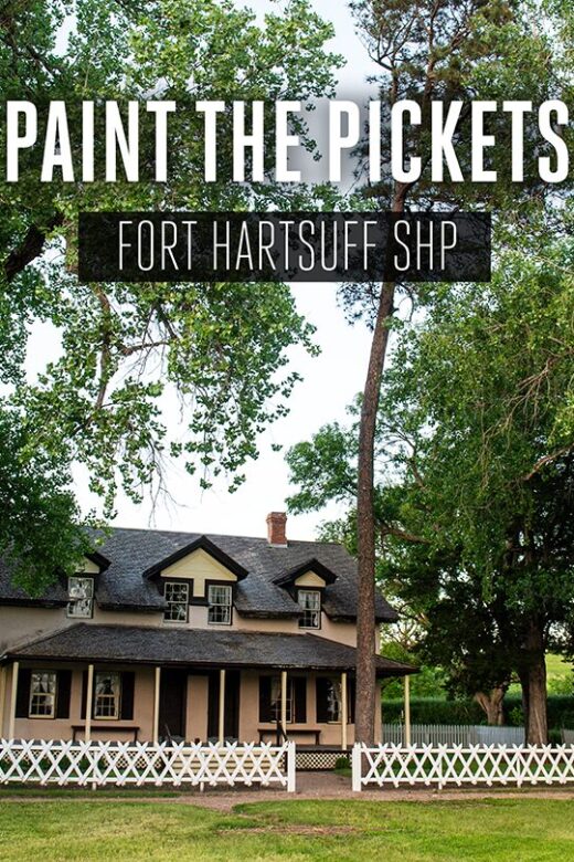 A historical building at Fort Hartsuff State Historical Park lined with a white picket fence.