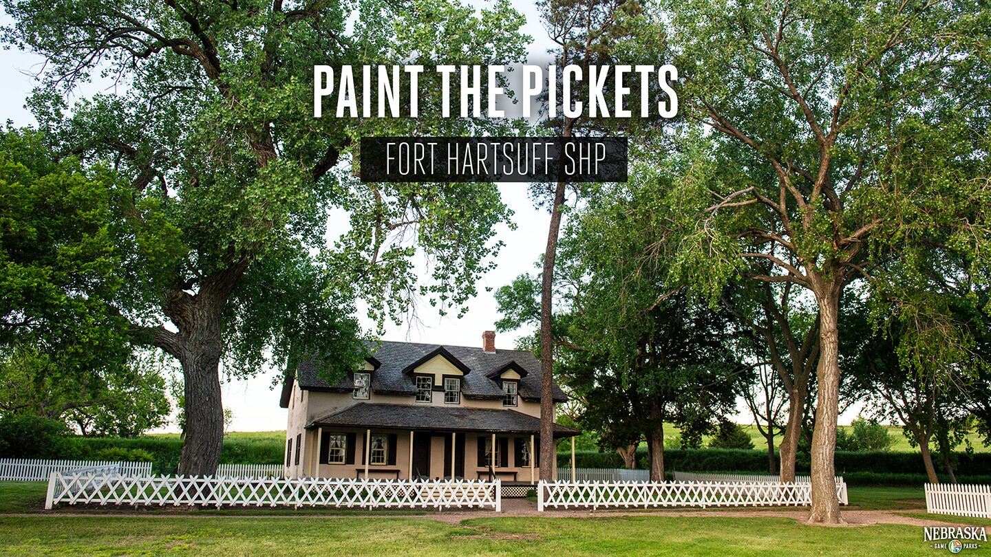 A historical building at Fort Hartsuff State Historical Park lined with a white picket fence.