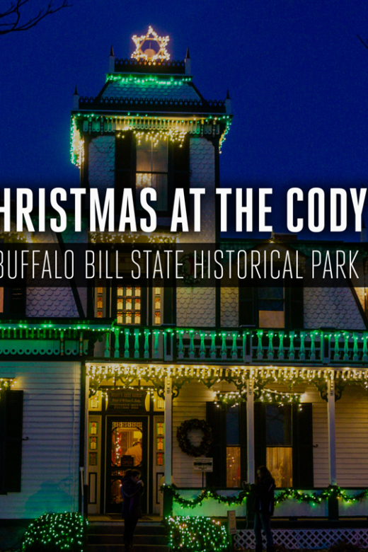 Buffalo Bill's historic mansion decorated with Christmas lights at night.