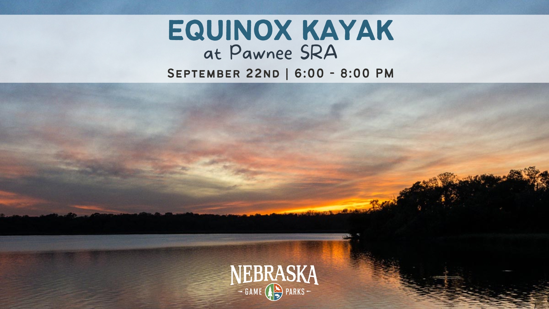 A sun sets over a tree-lined lake during summertime.