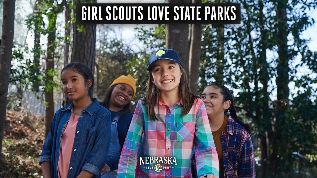 Four school girls hiking in a park.