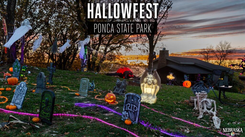 The sun sets in the background of a lawn at Ponca State Park filled with Halloween decor near a cabin.