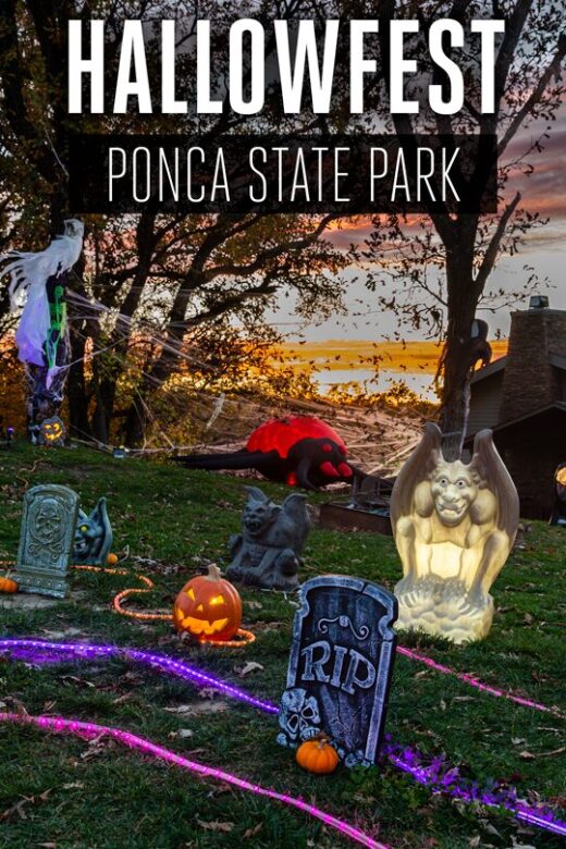 The sun sets in the background of a lawn at Ponca State Park filled with Halloween decor near a cabin.