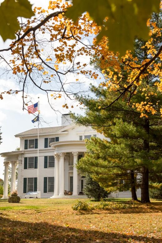 A view of Arbor Lodge Mansion in the fall through the trees.