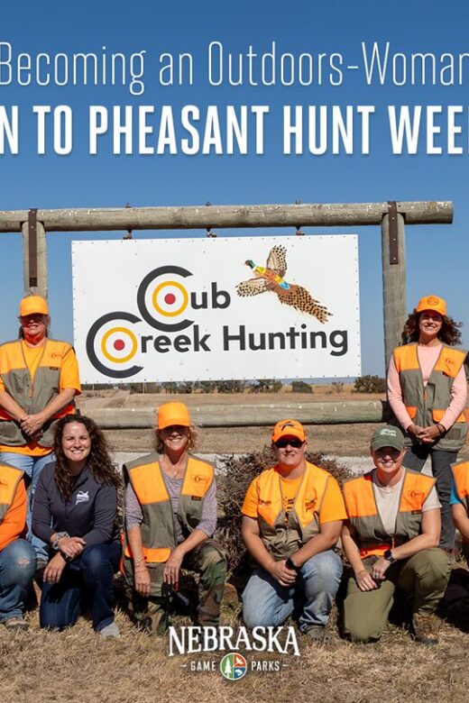 Women in hunting gear pose for a photo in front of a Cub Creek Hunting sign.
